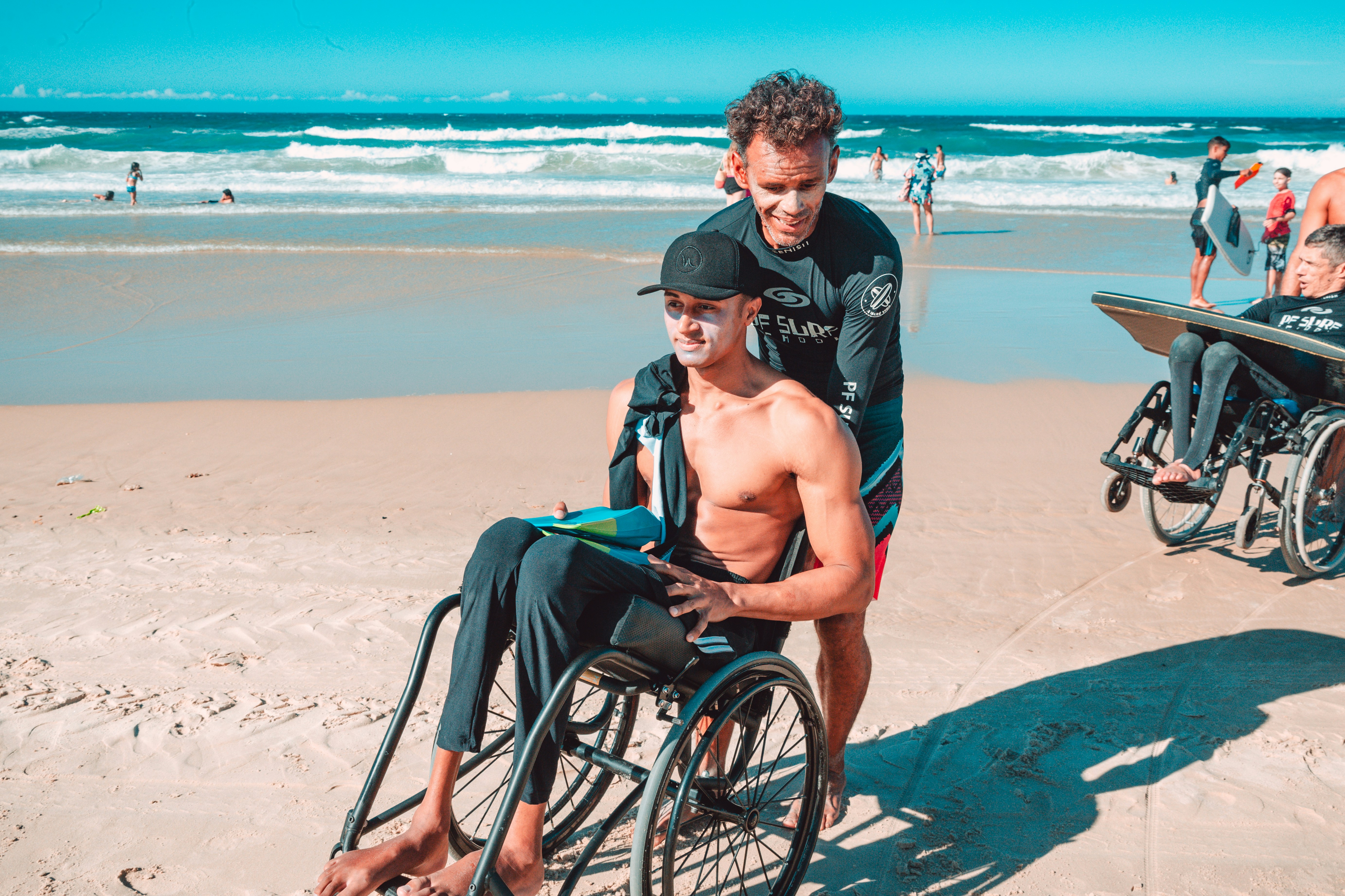 A wheelchair user enjoying a lively day at the beach with friends