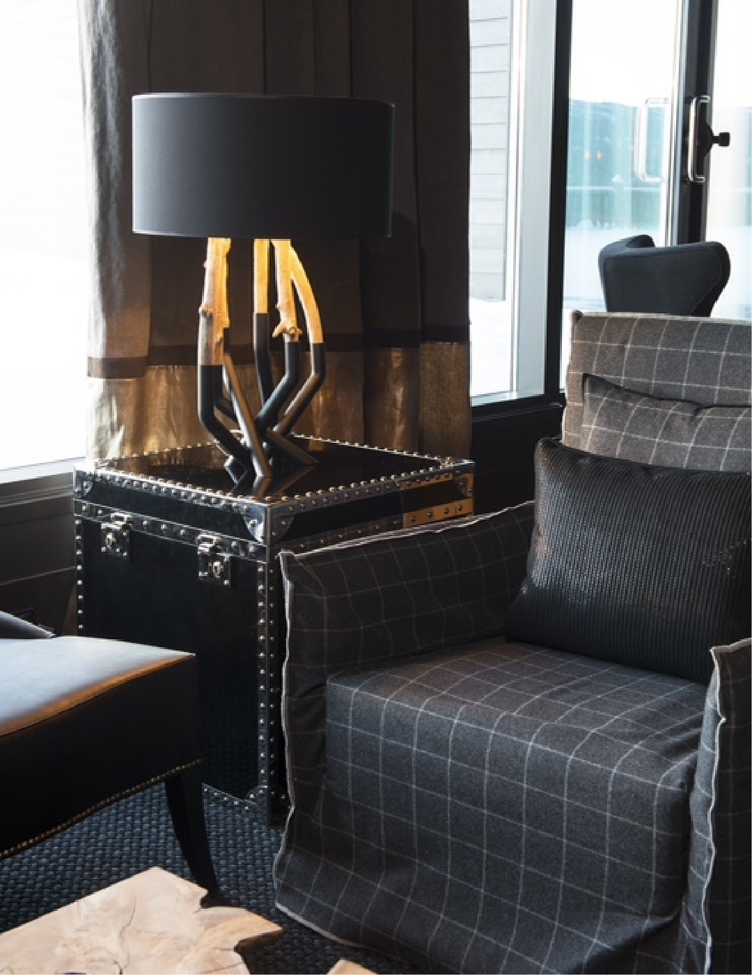 Dark tartan lounge seating beside a window at Highland Lodge