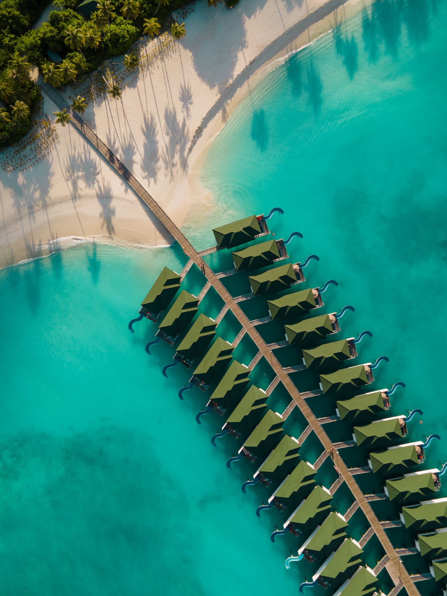 Aerial view of Siyam World Maldives overwater villas, beach and turquoise lagoon